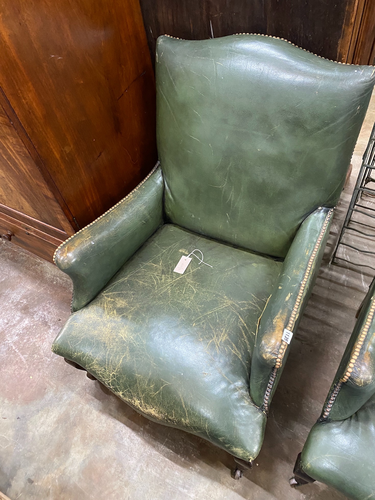 A pair of Victorian studded green leather library chairs on cabriole legs, width 69cm, depth 70cm, height 92cm